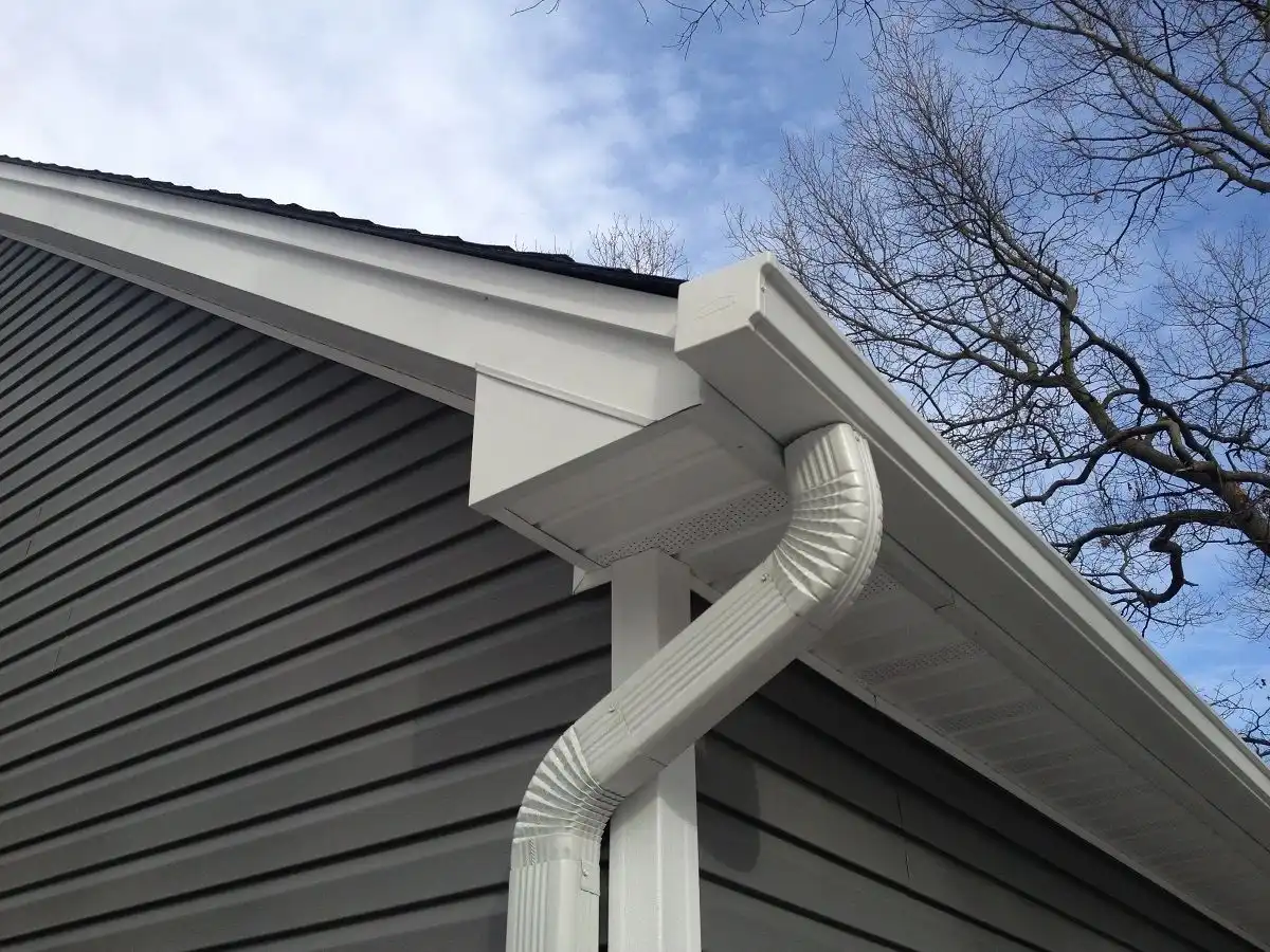 Seamless eavestroughs running along a finished roof edge.
