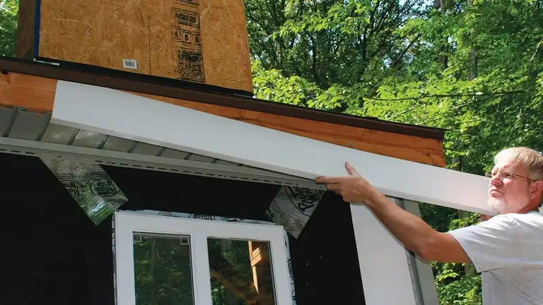 Vinyl fascia being installed along a roof edge.